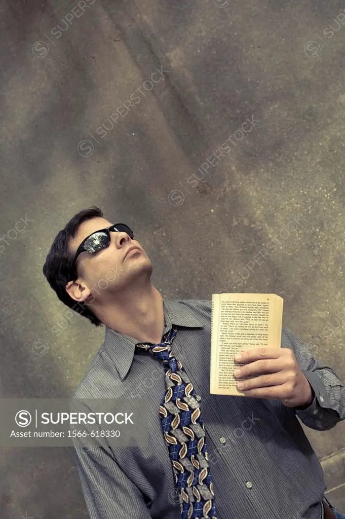 Young man outside, holding a book