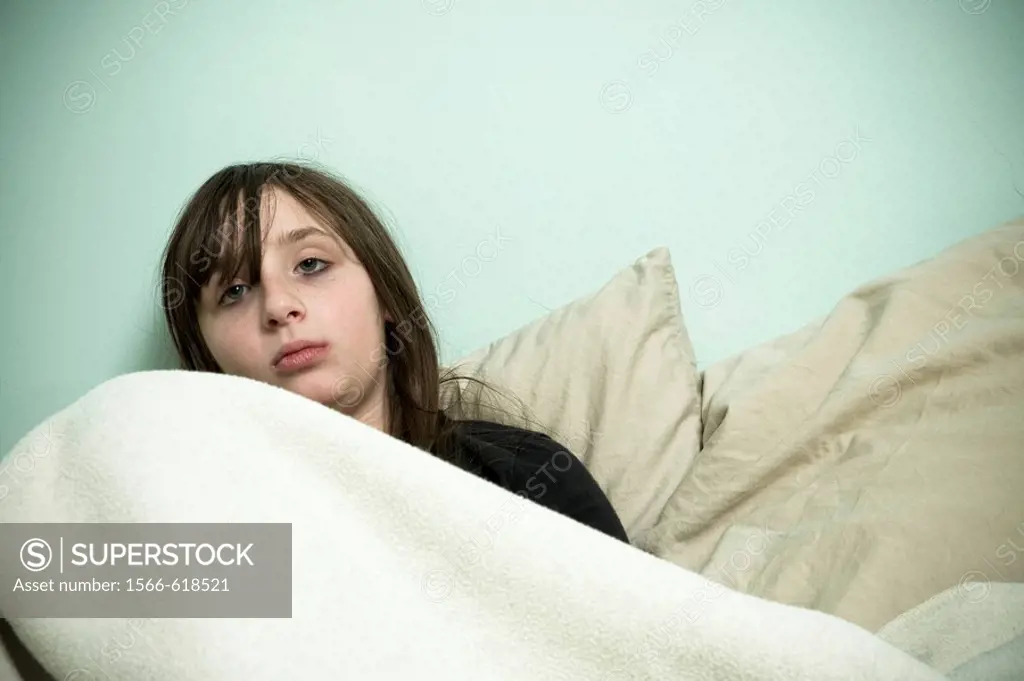 Preteen girl lying on her bed.