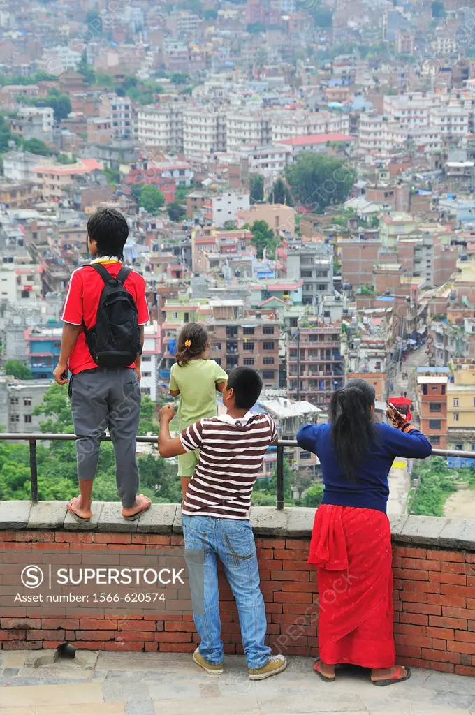 Family looking at Kathmandu city from Swayambhunath temple, Nepal.