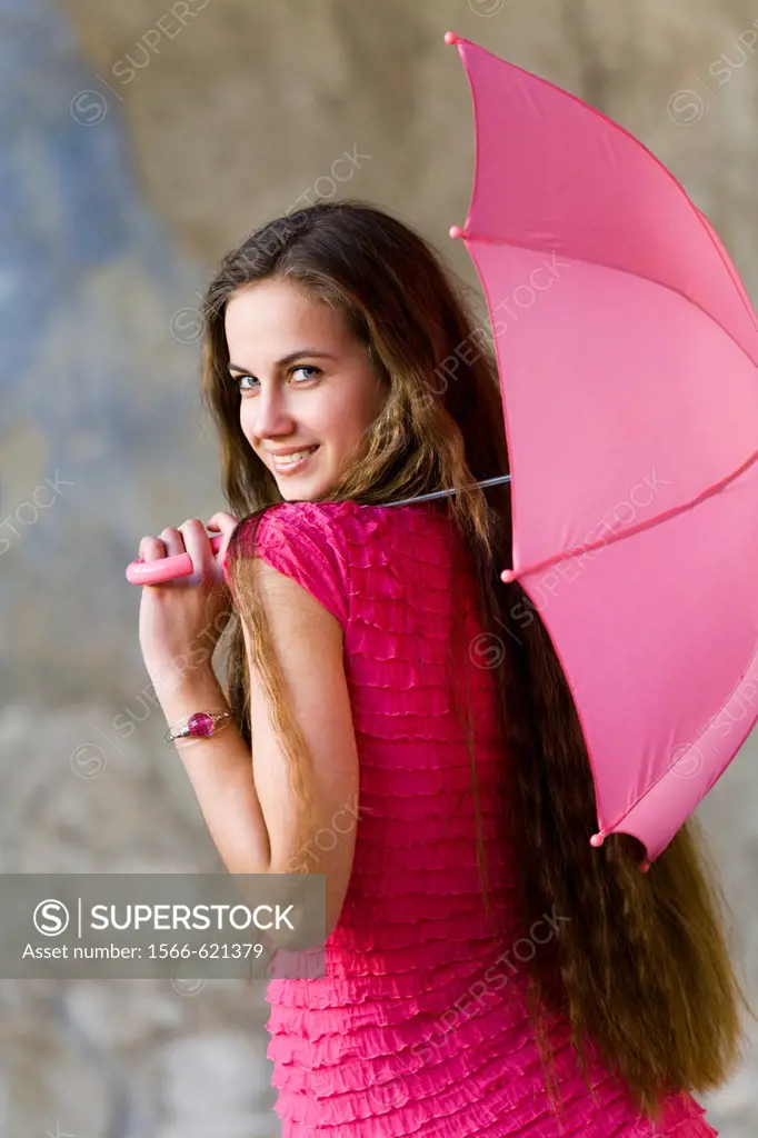 Flirting young woman with a small umbrella