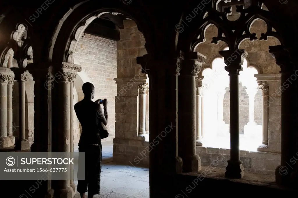 Visitor taking pictures in the cloister of the Sant Pau del Camp Benedictine monastery, Barcelona. Catalonia, Spain