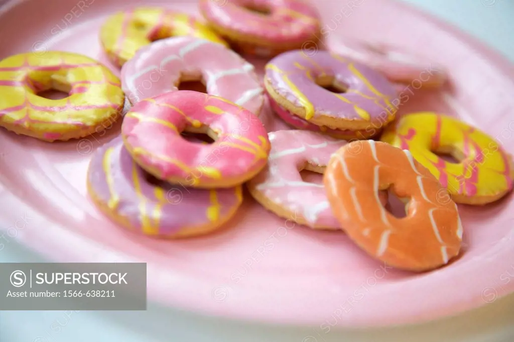Selection of coloured iced biscuits on a paper plate