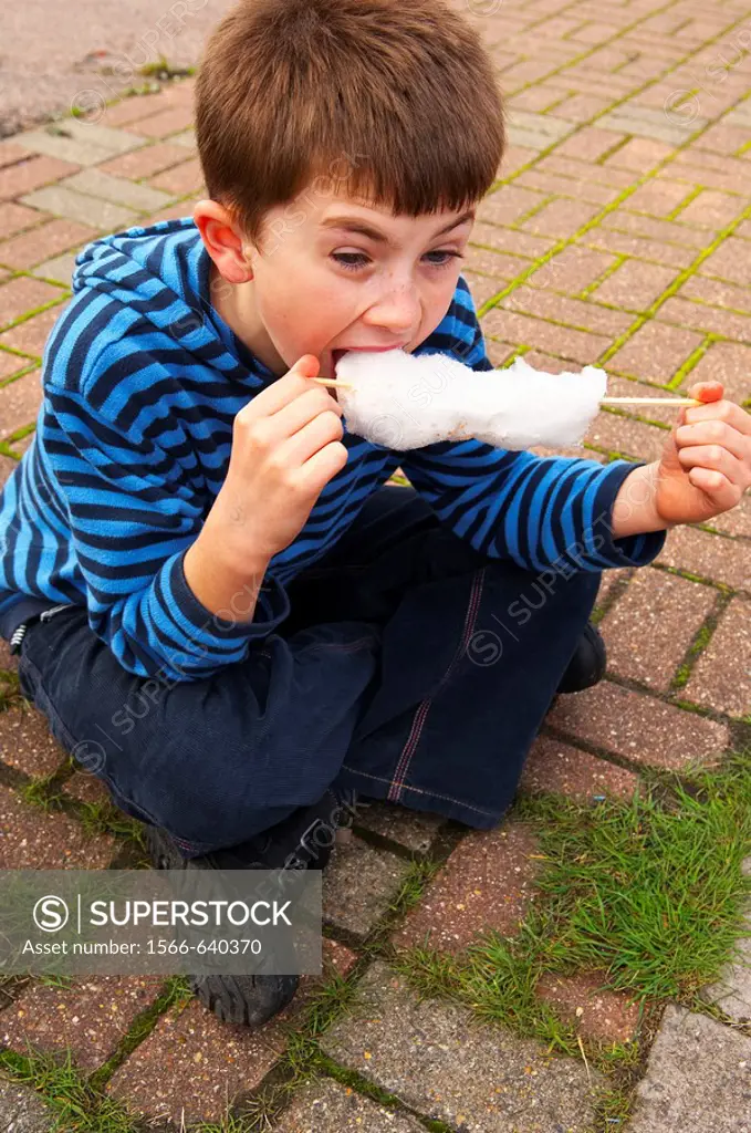 A  picture of a 10 year old boy eating candy floss in the Uk
