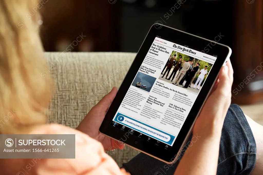 Close up of a woman reading online newspaper New York Times news from an iPad