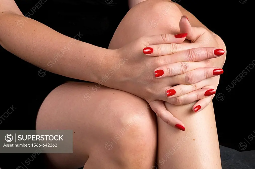 close view of woman´s hands folded across knees