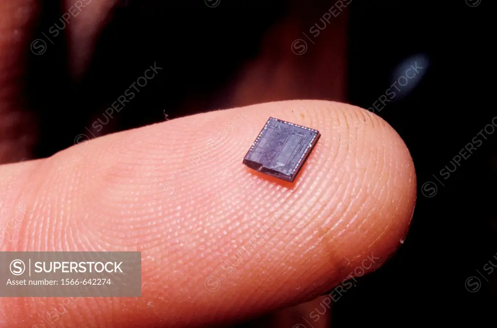 extreme close up of electronic chip on finger tip