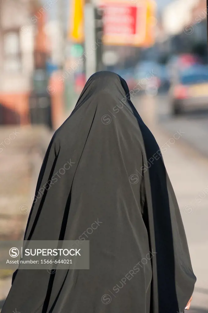 A Muslim woman wearing a Burka walks down Stoney Stanton Rd in Coventry, West Midlands, England