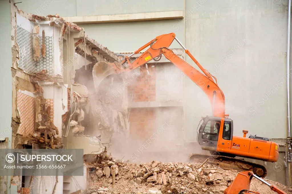 A backhoe is used to demolish a reinforced concrete building in Fatima, Portugal.
