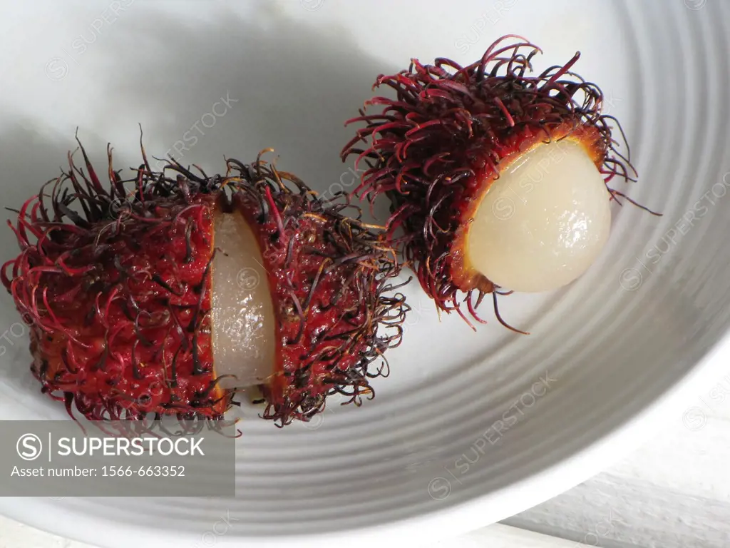 Rambutan fruit cut open on plate, Big Island, Hawaii, USA