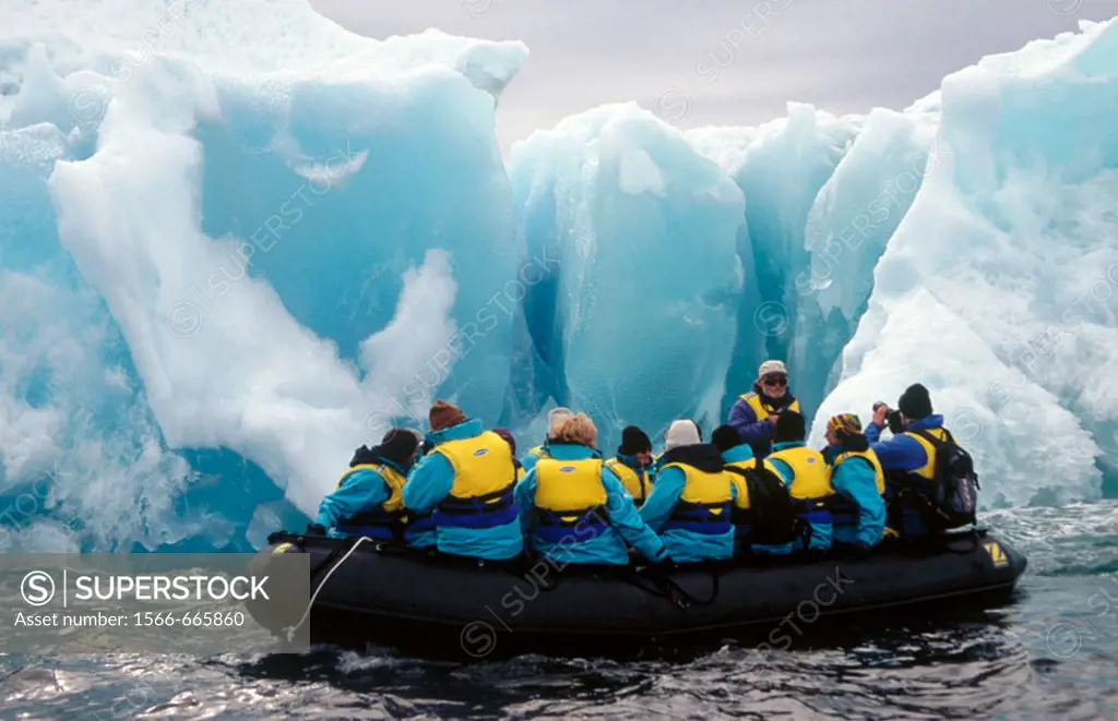 Zodiac with tourists. Past Jade coloured iceberg. Dumont d´Urville, Antarctica.