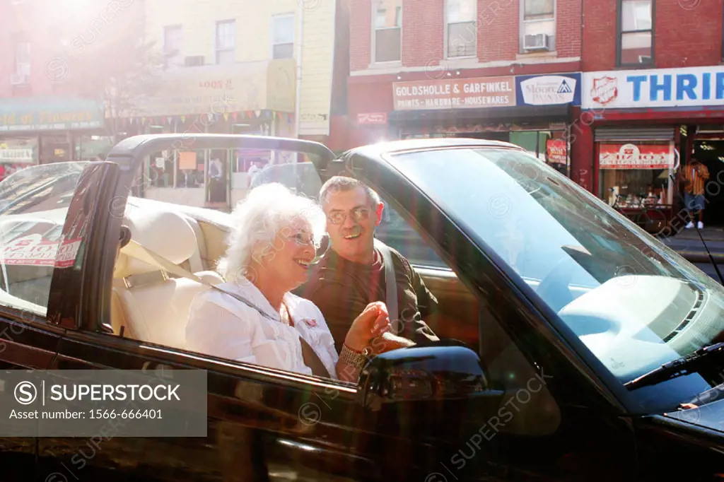 Couple relaxing in convertible car, Greenwich Village,  New York City.