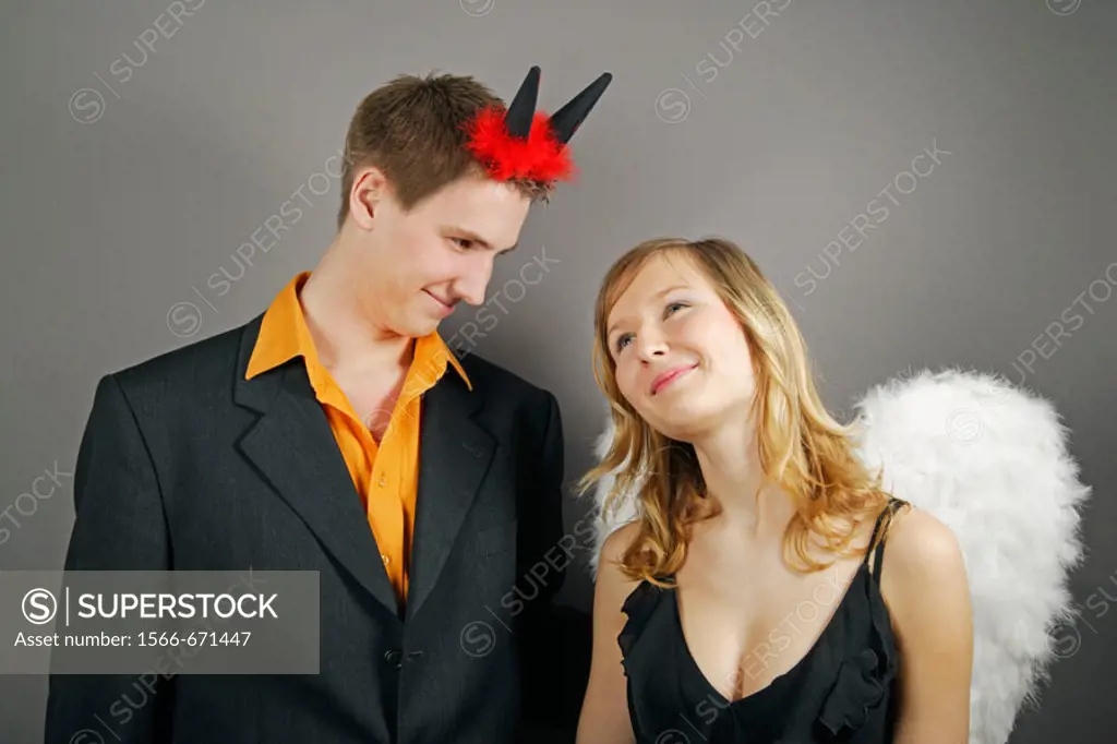 Young couple as angel and devil