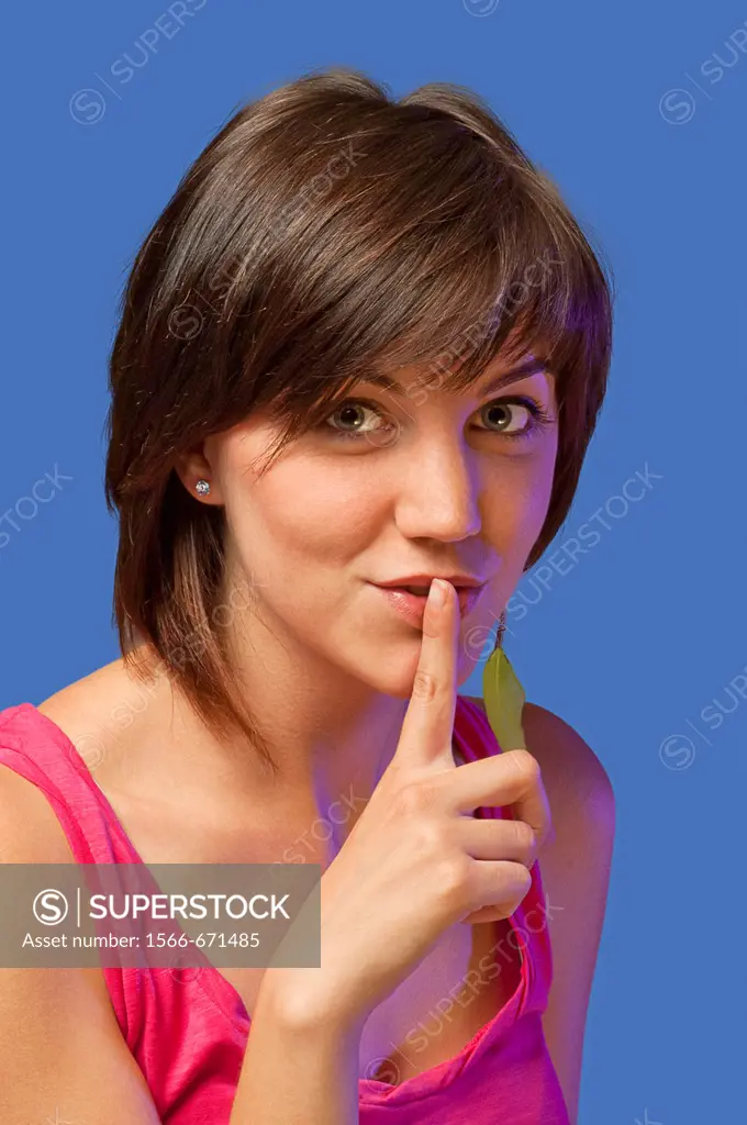 Young woman with finger on lips.