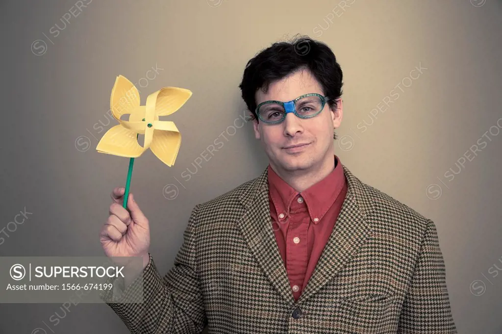 Man with broken glasses holding a pinwheel