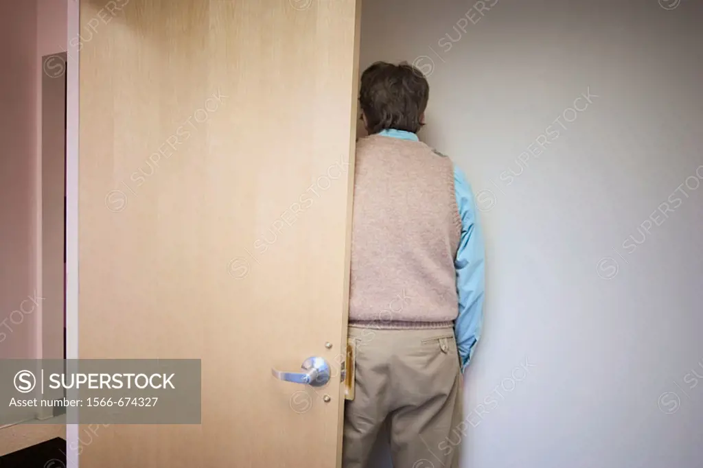 Back of a man standing by a door in an office building lobby