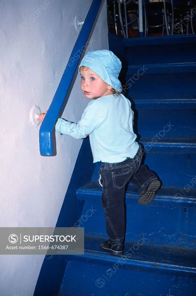 2 year old girl climb staircase in bar
