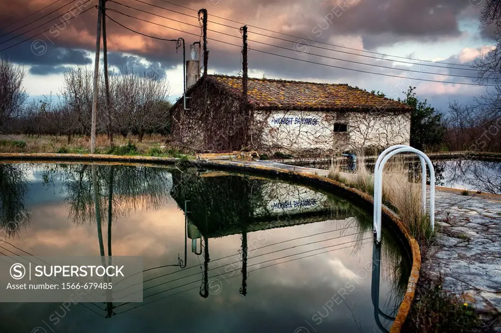 Abandoned house reflected in the water of a reservoir  Tarragona, Spain