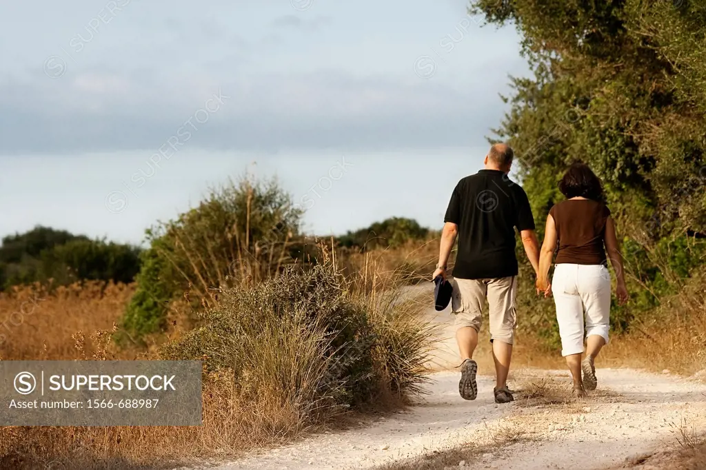 Couple walking in the countryside. Minorca, Balearic Islands, Spain.