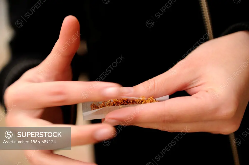 Young woman rolling a joint.