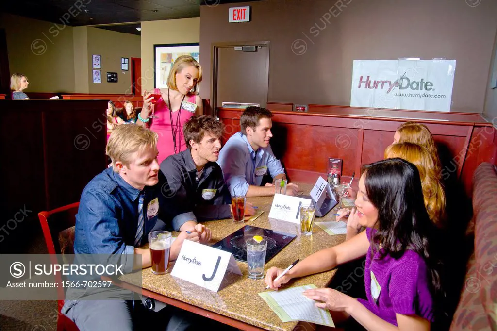 A hostess watches as speed dating couples fill out evaluation forms at a California restaurant  In speed dating, men and women are rotated to meet eac...