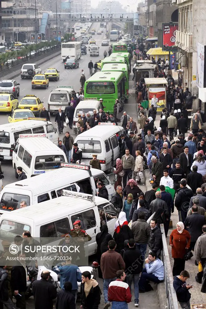 Crowd of people staying at a bus stop filled with microbusses and taxis, waiting for passengers in downtown Damascus, Syria, Near East, Asia