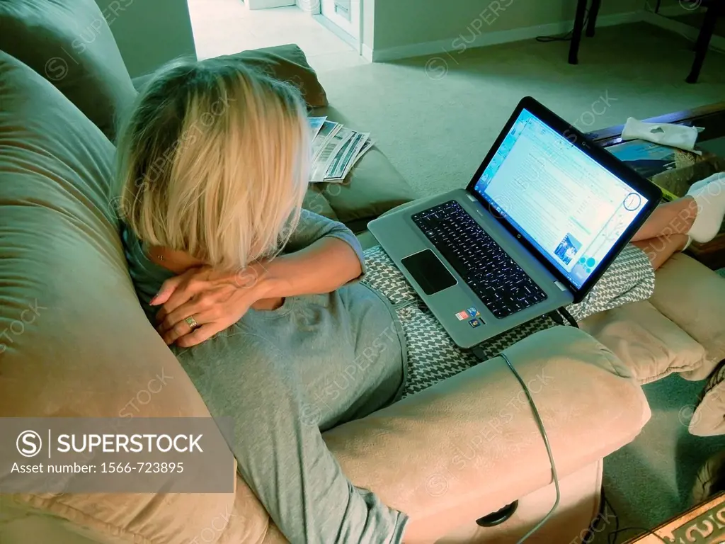 Adult female relaxing with laptop computer