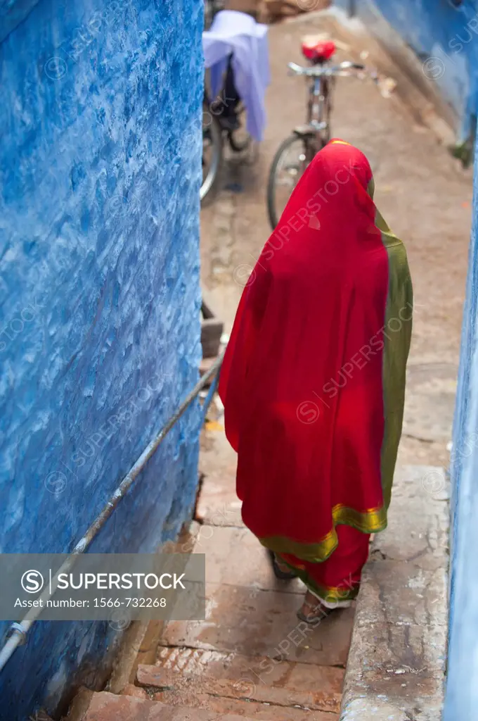 Indian Woman walking in narrow street, Blue city, Jodhpur, Rajasthan, India