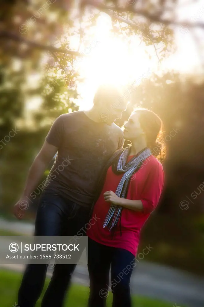 A young couple outdoors in the park.