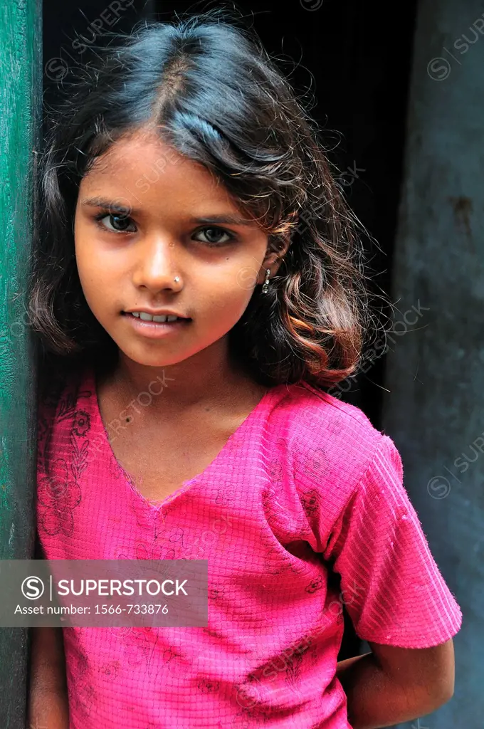Young girl at narrow street of the old town near the Ganges River