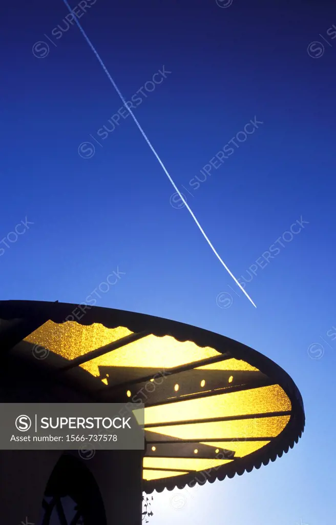 Contrail of an aircraft above the low sun of southern Italy
