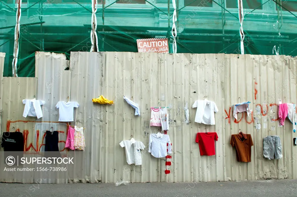 funny place to hang laundry next to warning sign and construction site in Georgetown, Penang, Malaysia