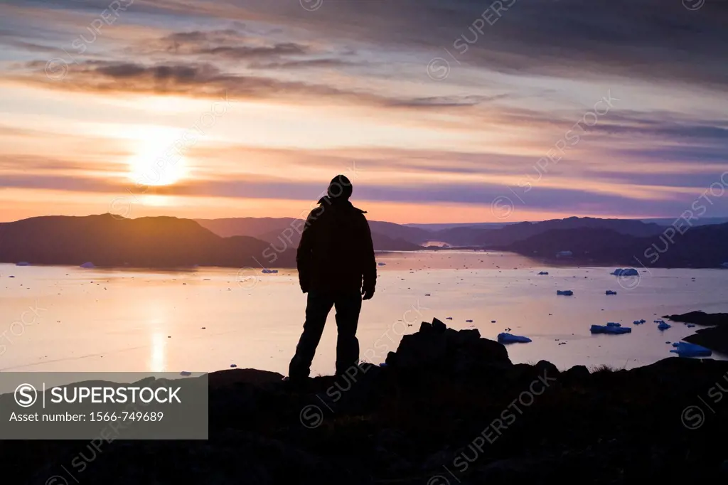 Man looking at the fjord outside Narsaq, South Greenland