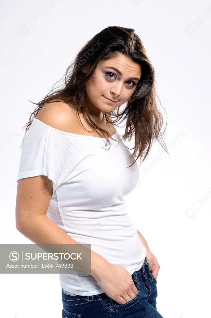 A long haired, pretty girl dressed in a tight fitting, bare shoulder, white top is seen from the side, and she turns toward the camera her hands in he...