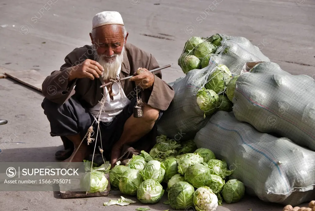 Old man weighing cauliflowers in a market  Kashgar, Xinjiang, China