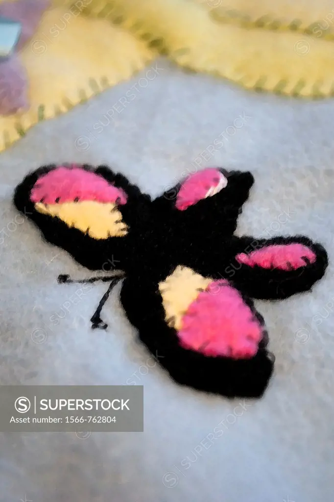 A black yellow and pink butterfly appliqued onto a fleece baby quilt