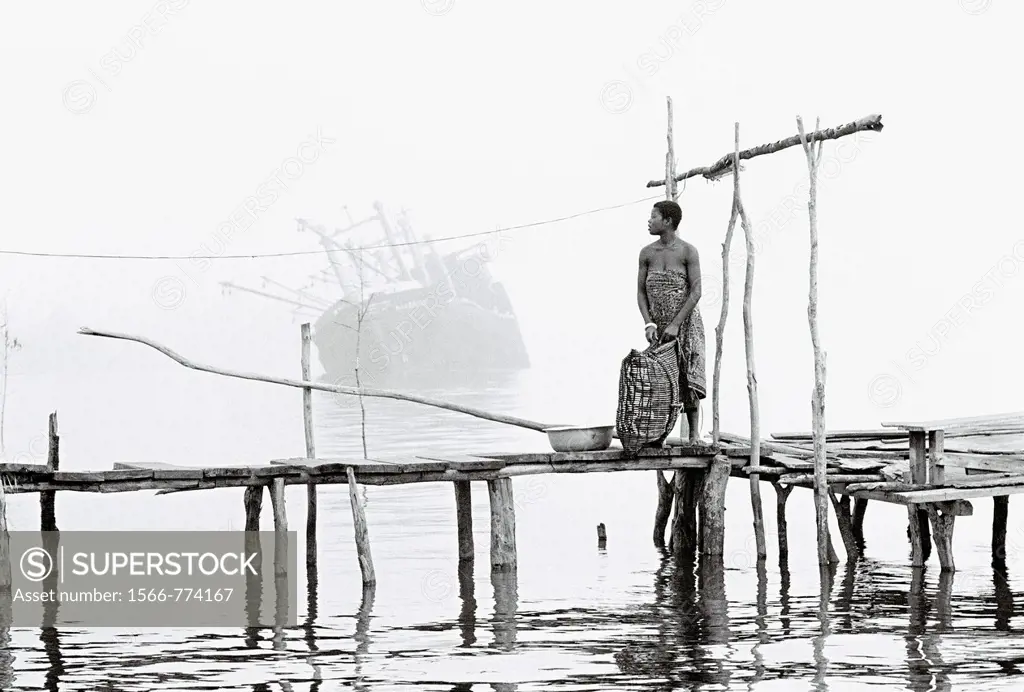 River Niger delta, Bendel State, Nigeria  Woman on wooden jetty at Bennett Island Anchorage on the Warri River shipping channel