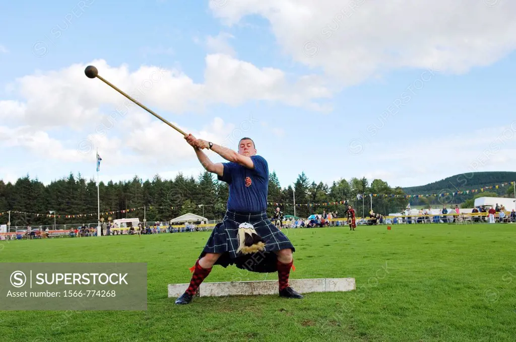 Lonach Highland Games at Strathdon, Grampian, Scotland, UK  Competitor wearing traditional kilt throwing the hammer