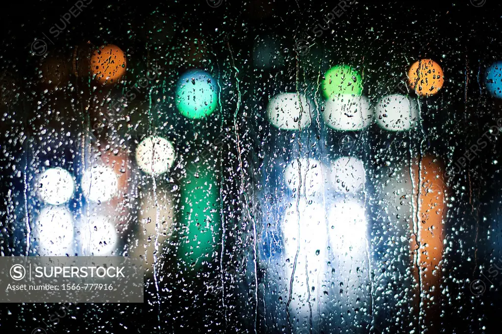 luces desenfocadas en un vidrio lleno de gotas de agua