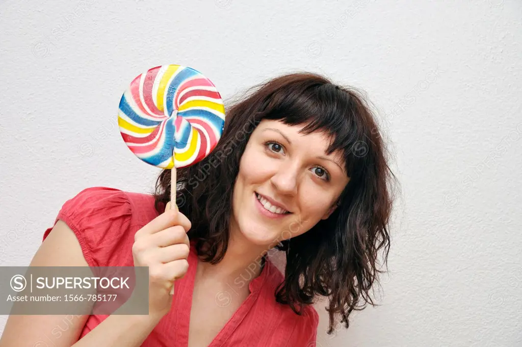 Smiling young woman with lollypop