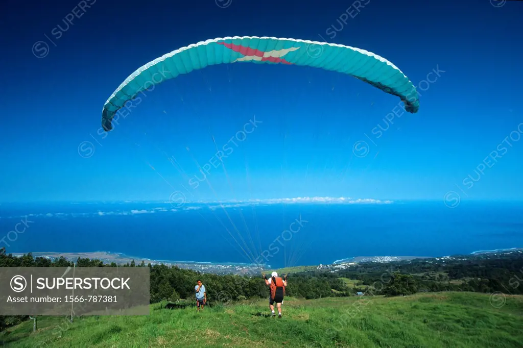Paraglider taking off over Saint Leu town, La Reunion Island (France), Indian Ocean