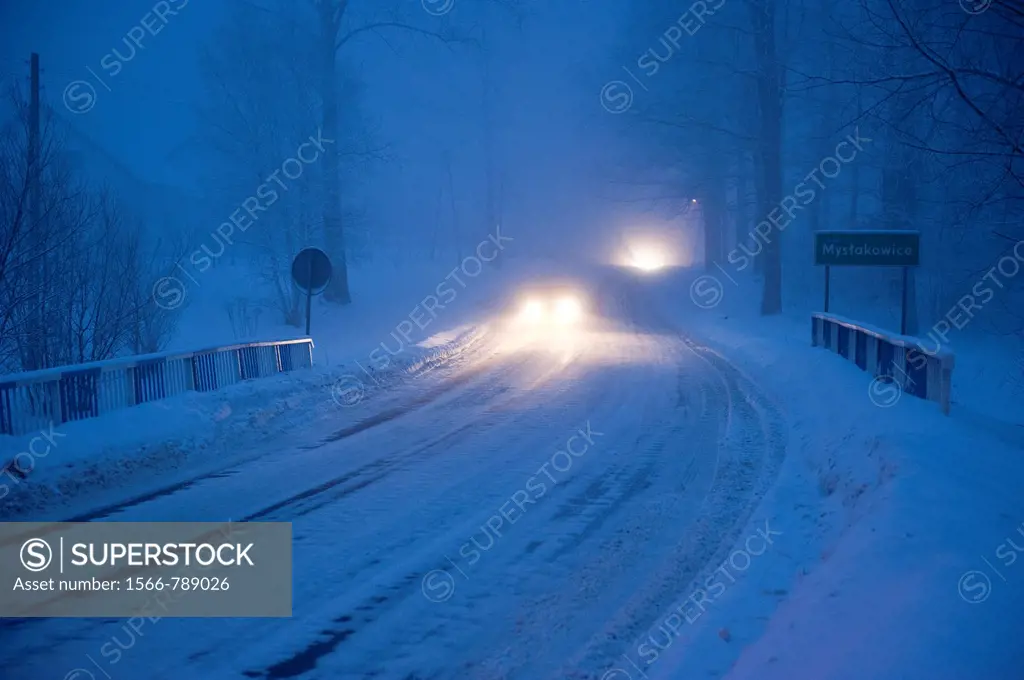 Cars circulating at bight over a frozen road, Myslakowice, Poland