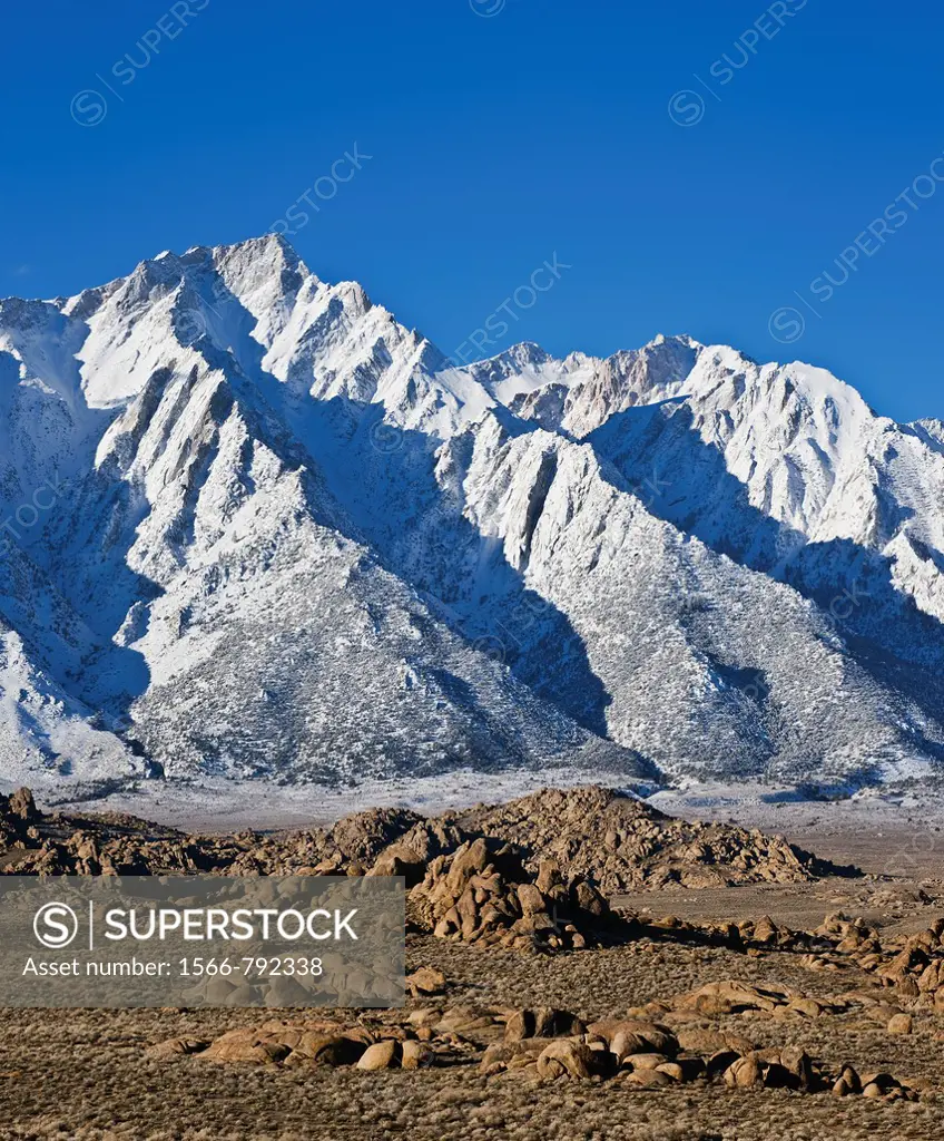 Granite rock formations of Alabama Hills with Lone Pine peak and Sierra Nevada mountains in background, California