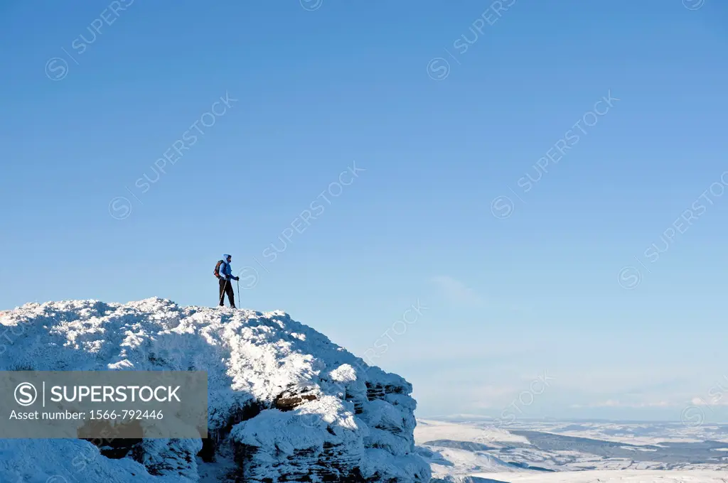 Female hiker stands on summit of Corn Du in winter, Brecon Beacons nationl park, Wales