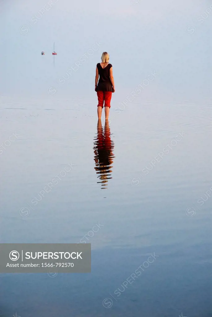 Female standing in shallow water of German Wadden Sea, Juist, Lower Saxony, Germany