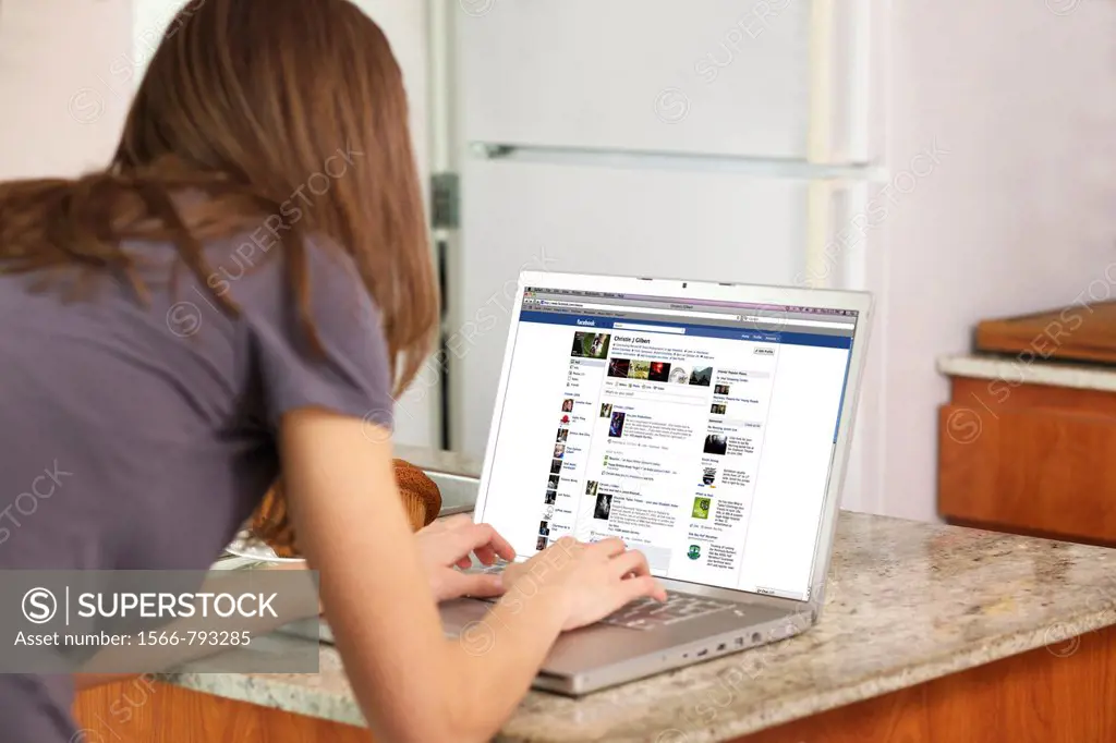 Woman checking her Facebook account on a laptop
