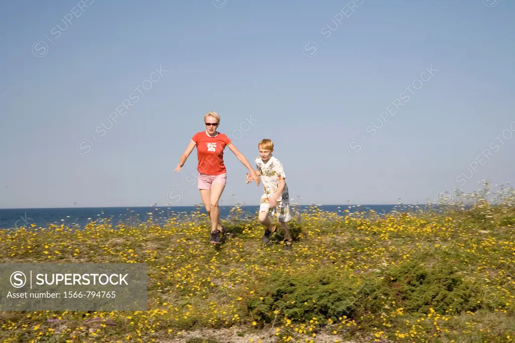 Woman and Kid Running Hand in Hand on Saaremaa Coast, Saare County, Estonia