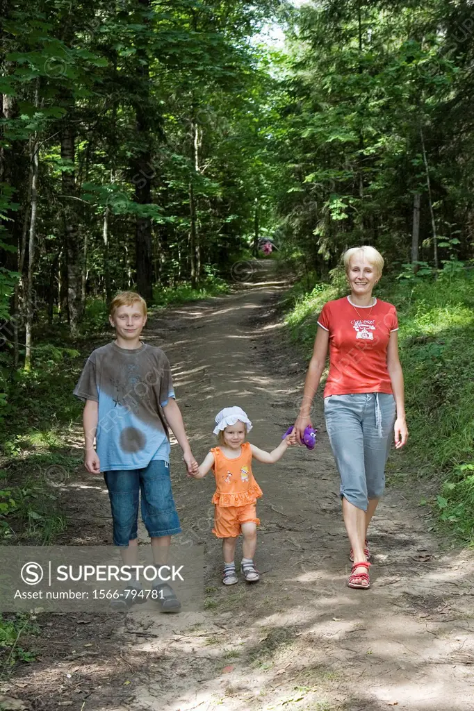 Young Woman With Kids, Family Walking Hand in Hand in Forest