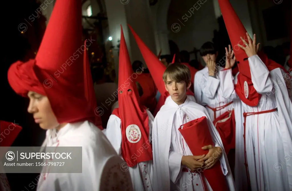 Young penitents stand inside a church waiting to start an Easter Holy Week procession in Carmona, Seville province, Ansalusia, Spain, May 19, 2001  Th...