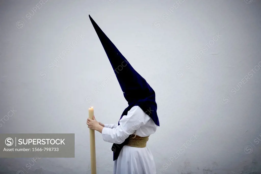 A penitent holds a candle during an Easter Holy Week procession in Carmona village, Seville province, Andalusia, Spain, April 19, 2011