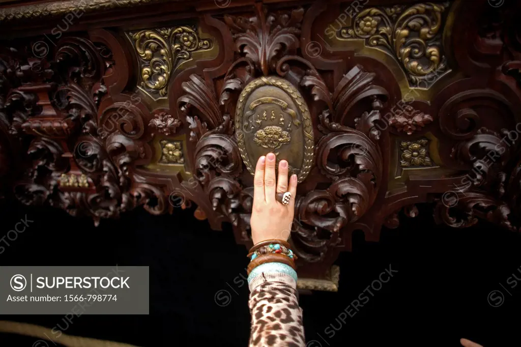 A woman touches a throne during an Easter Holy Week procession in Carmona village, Seville province, Andalusia, Spain, April 20, 2011